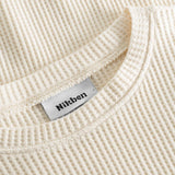 Close up on round neck on an off white waffle-patterned cropped sweatshirt