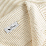 Close-up of open collar on an off white waffle-patterned shirt.