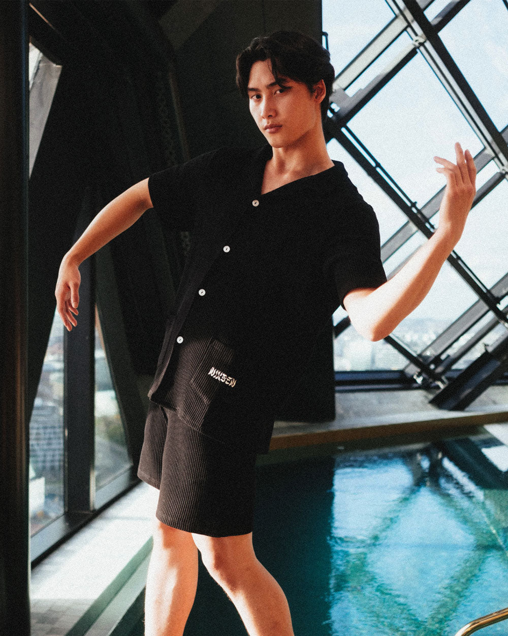 Male model wearing black mid length shorts with drawstring and two side pockets