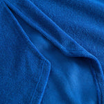 Close up on stitchings on a blue kaftan in terry toweling fabric.