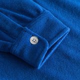 Close up on sleeve on a blue kaftan in terry toweling fabric.