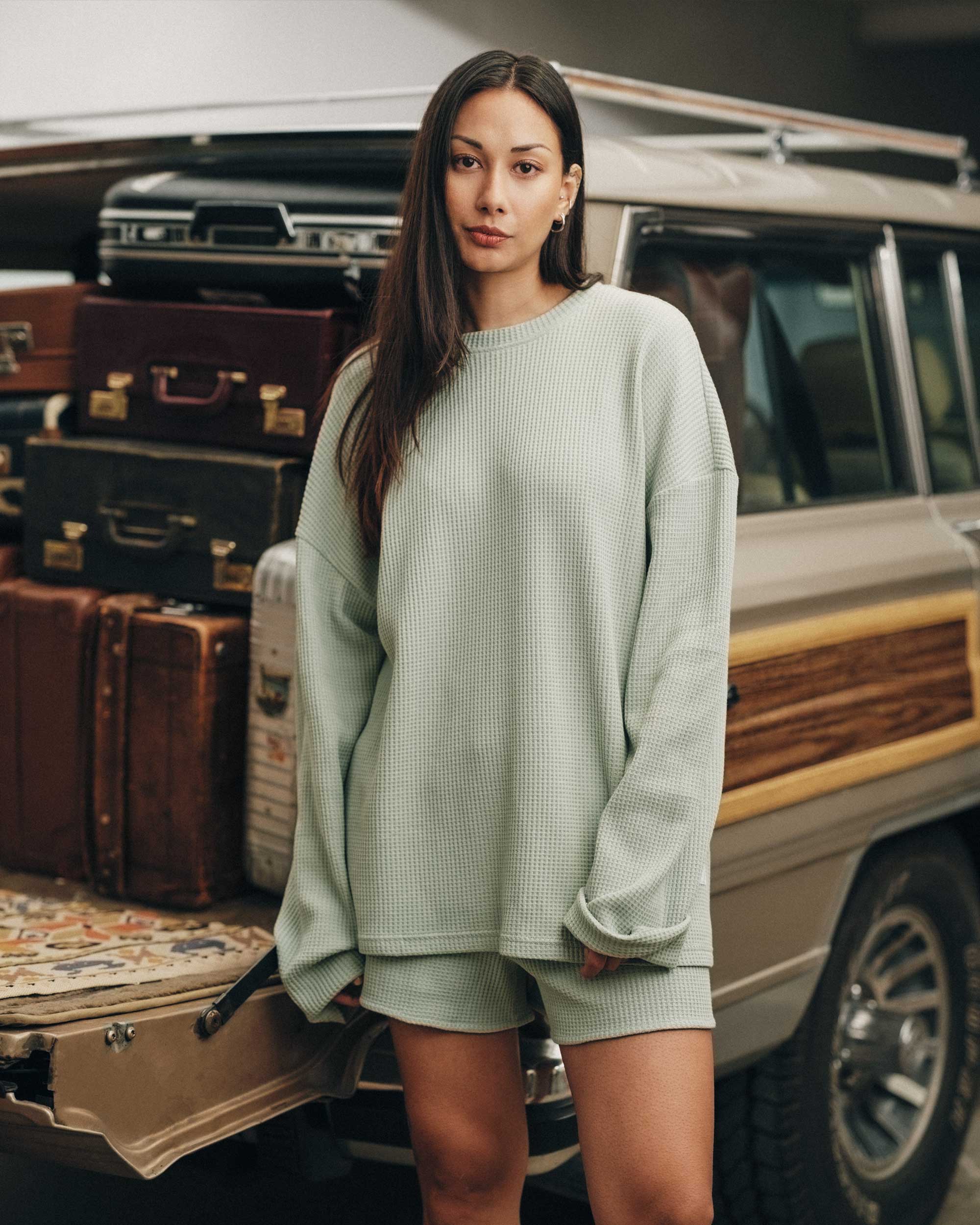 Female model wearing mint green waffle-patterned sweatshirt with a stitched-on material label.