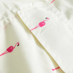 Back pocket on yellow swim trunks with pink flamingos