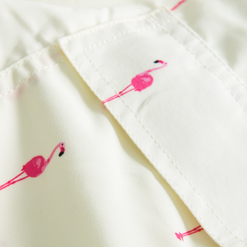 Back pocket on yellow swim trunks with pink flamingos
