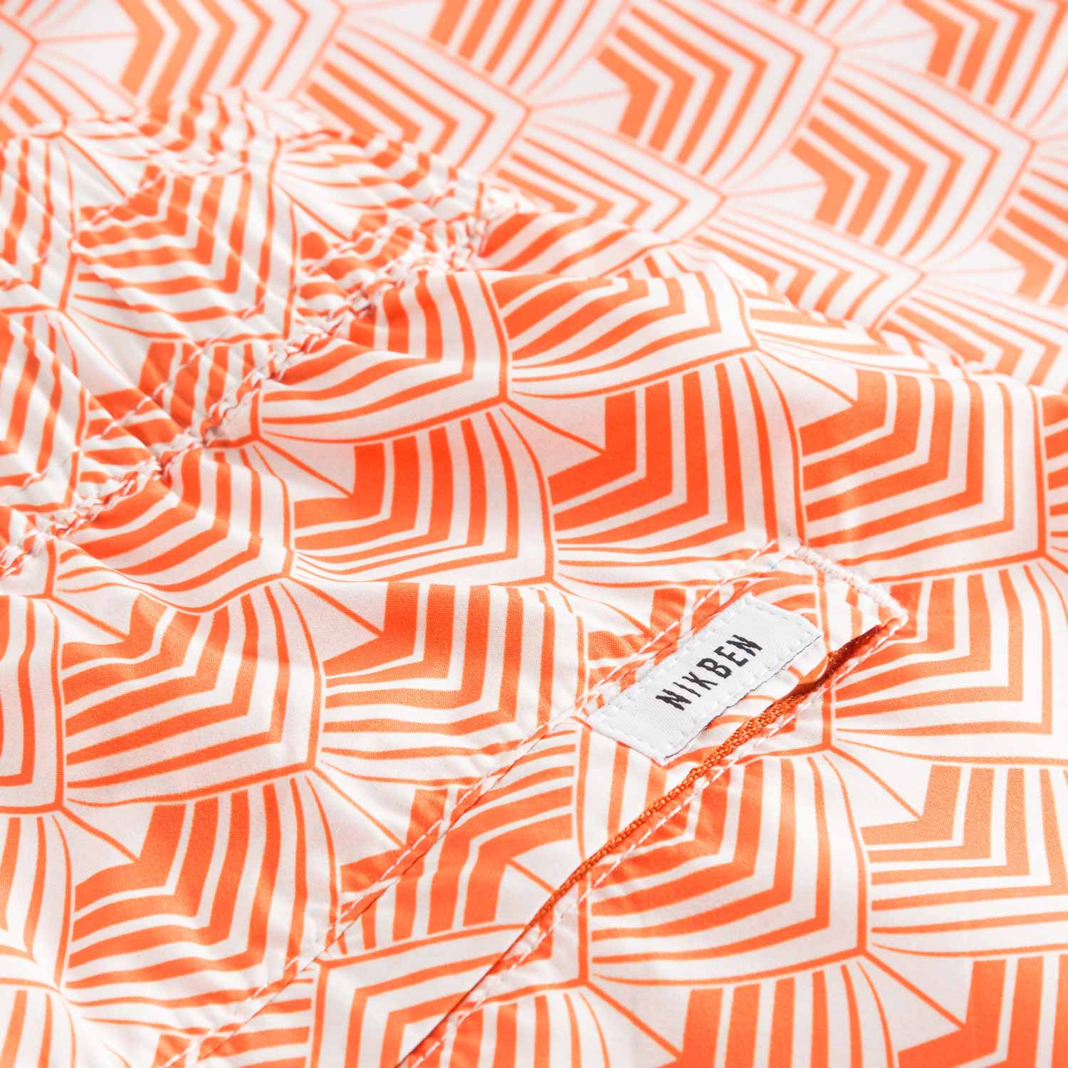 Logo on orange/off white swim trunks